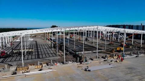 Warehouse construction process with metal structures and roofs Stock Photos