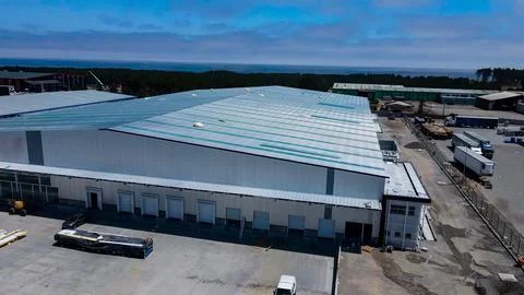 Warehouse construction process with metal structures and roofs Stock Photos
