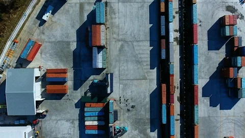 Warehouse with containers. Reach stackers unload the train. Loaders. aerial view Stock Footage 97532638