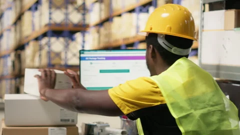 Warehouse employee registering orders with tracking info on airway bill tags Stock Footage 315708393