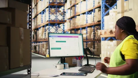 Warehouse employee using package tracking software on computer monitor Stock Footage 312836801