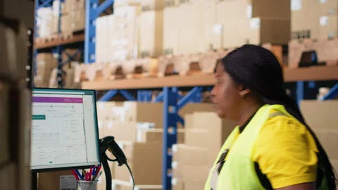 Warehouse employee using package tracking software on computer monitor Stock Footage 313087560