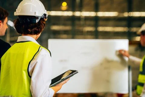 Warehouse engineer with safety vest using tablet for checking goods on shelves Foto stock