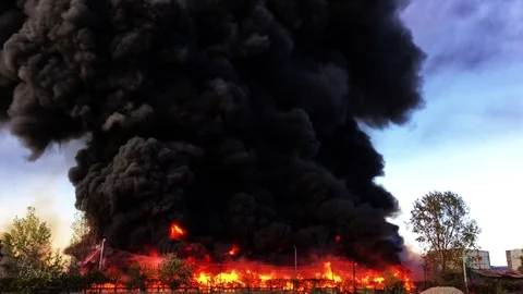 Warehouse engulfed in raging fire with huge column of smoke Stock Footage 78492373