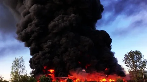 Warehouse engulfed in raging fire with huge column of smoke Stock Footage