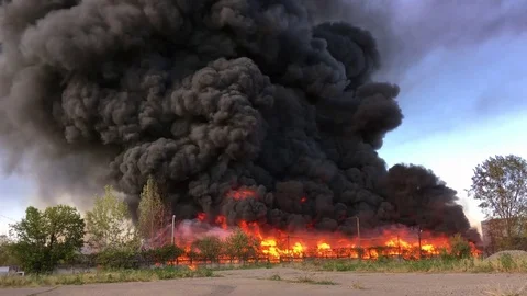 Warehouse engulfed in raging fire with huge column of smoke Stock Footage 78492701