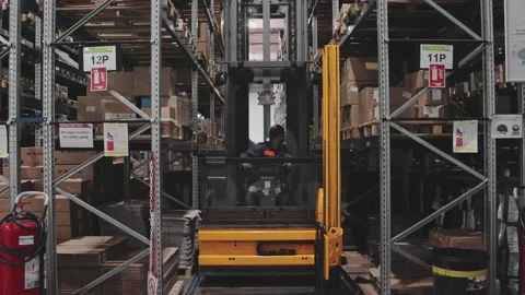 Warehouse Forklift Driver Between Racks Shelves Working with boxes Preparing ord Vídeo Stock 142135484