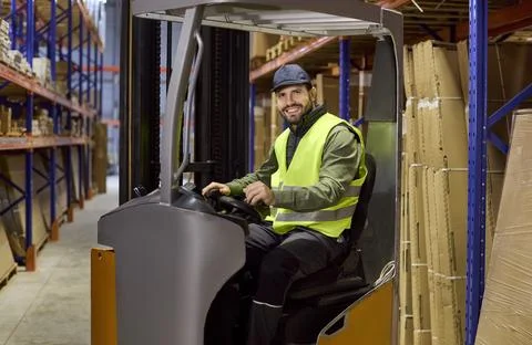 Warehouse forklift operator moving pallets on racking for streamlined logistics 库存照片
