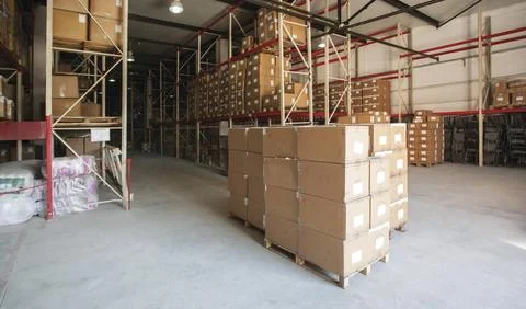 Warehouse interior storing stacked boxes on pallets in industrial racks Photos