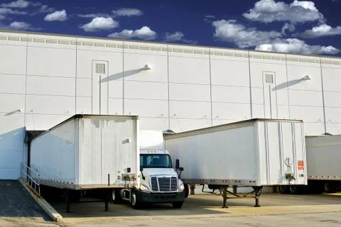 Warehouse loading docks - business district. semi trucks and trailers loading 库存照片
