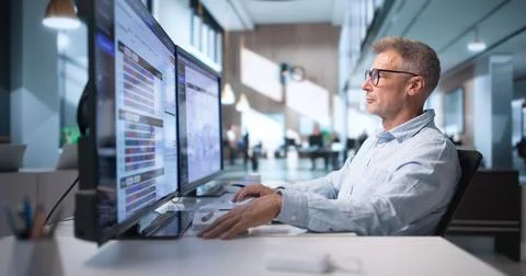 Warehouse Manager Analyzes Inventory Data On Computer To Improve Shipping Wor Stock Photos