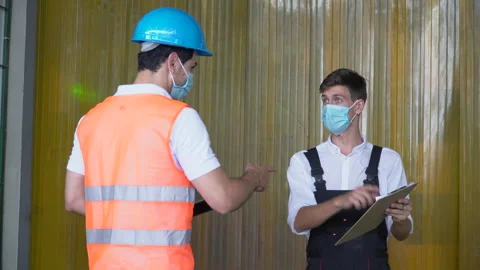 Warehouse manager and worker wearing protective medical face mask using table Stock Footage 143405776
