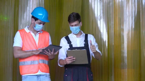Warehouse manager and worker wearing protective medical face mask using table Stock Footage 143405800