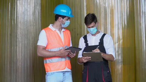 Warehouse manager and worker wearing protective face mask using tablet comput Stock Footage 159659309
