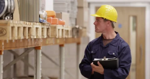 Warehouse manager inspecting stock levels in a manufacturing plant. Stock Footage 53372801