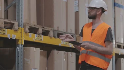 The warehouse manager inspects the warehouse. A man in a modern warehouse Video stock 296319794