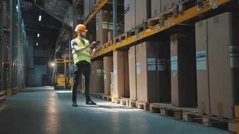 Warehouse manager of a large factory. A manager with a tablet in a warehouse Видео 296319637