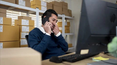 Warehouse manager multitasking with phone call Stock Footage 326276008