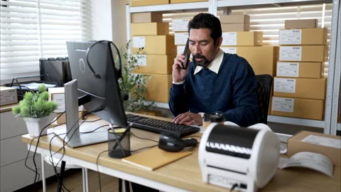 Warehouse manager multitasking with phone call Stock Footage 326276723