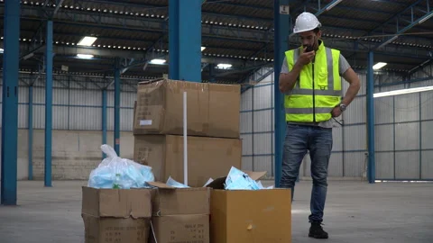 Warehouse manager speaking through walkie-talkie to complain worker from Dete Stock Footage 146818738