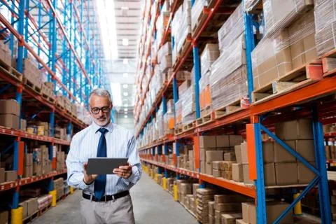 Warehouse manager taking notes on his tablet computer 스톡 사진