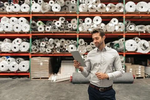 Warehouse manager using a tablet while checking stock Stock Photos