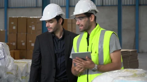 Warehouse manager walking with  warker man using tablet computer checking lis Stock Footage 144267092
