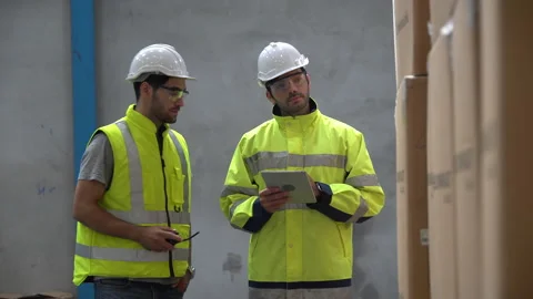 Warehouse manager walking with  warker man using tablet computer checking lis Stock Footage 144268034