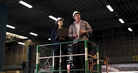 Warehouse managers on lifting platform coordinate logistics operation using Vidéo 307012125