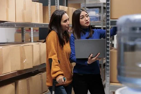 Warehouse managers preparing order, checking pick ticket on laptop Foto stock