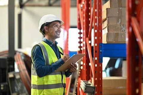 Warehouse managers standing between retail warehouse full of shelves and Stock Photos