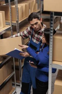 Warehouse managers taking parcel and checking code on tablet 스톡 사진