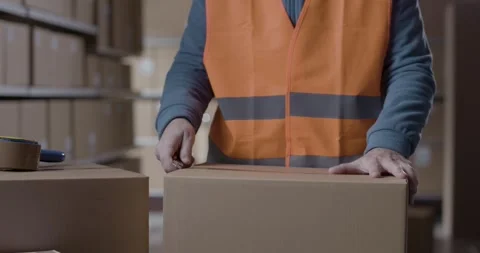 Warehouse operative opening a delivery box Stock Footage 297855985