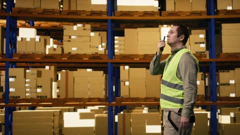 Warehouse operator reporting parcel status via two-way portable transceiver Vidéo 332908606