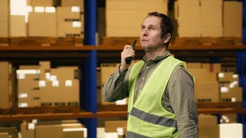 Warehouse operator reporting parcel status via two-way portable transceiver Stock Photos
