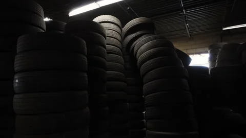 The warehouse or storage area filled with large stacks of tires. Tires are piled Stock Footage 297095619