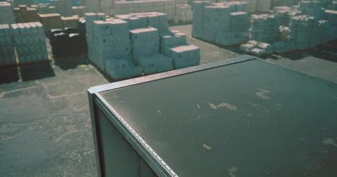 Warehouse overview showcasing stored containers and pallets during daylight Illustration