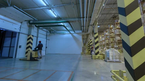 Warehouse pan left to right, loaders moving. Motion time lapse. UHD 4K Stock Footage