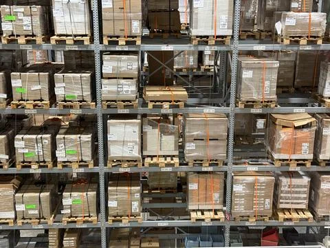 Warehouse shelves stacked with assorted pallets and boxes for storage and l.. Stock Photos