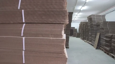 Warehouse with stacks of folded brown cardboard Video stock 88590502