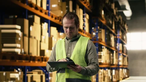 Warehouse staff scanning barcodes and shipment details on tablet Stock Footage 332910685
