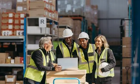 Warehouse staff smiling happily while watching a slideshow presentation on .. Foto stock