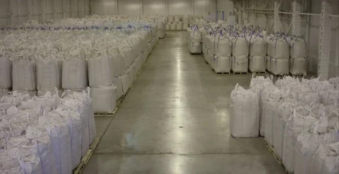 Warehouse for storage of fertilizers in bags. stack of big bag contain rice in Stock Footage