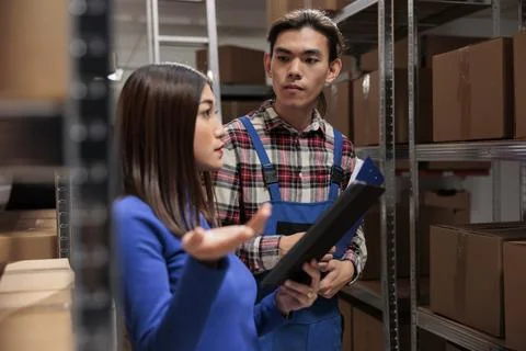 Warehouse supervisor explaining parcel storing quality control to coworker Stock Photos