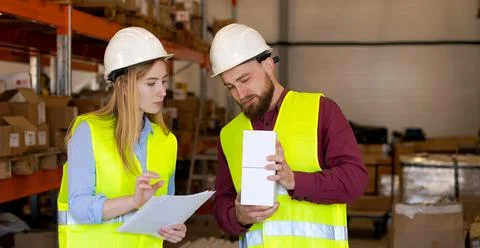 Warehouse Supervisor Explaining Product Specifications to Team Member 写真素材