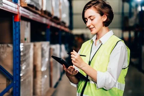Warehouse supervisor using tablet for controlling and checking goods on shelves Stock Photos