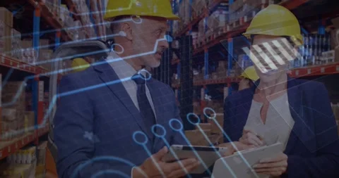 Warehouse supervisors checking inventory in aisle as circuit graphics emerging Stock Footage 319851741