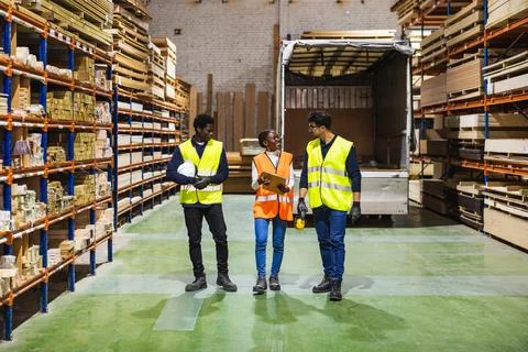 Warehouse teamwork discussing timber inventory and logistics Stock Photos