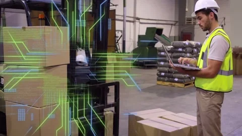 Warehouse tech typing laptop, initiating AR overlay on forklift and boxes, Stock Footage 335739380