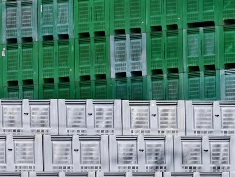 Warehouse Wall Featuring Systematically Stacked Plastic Crates In Vibrant Stock Photos